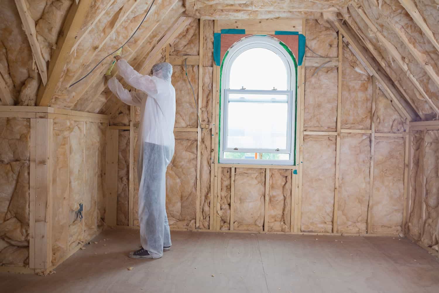 Insulation specialist placing wool insulation on the attic walls