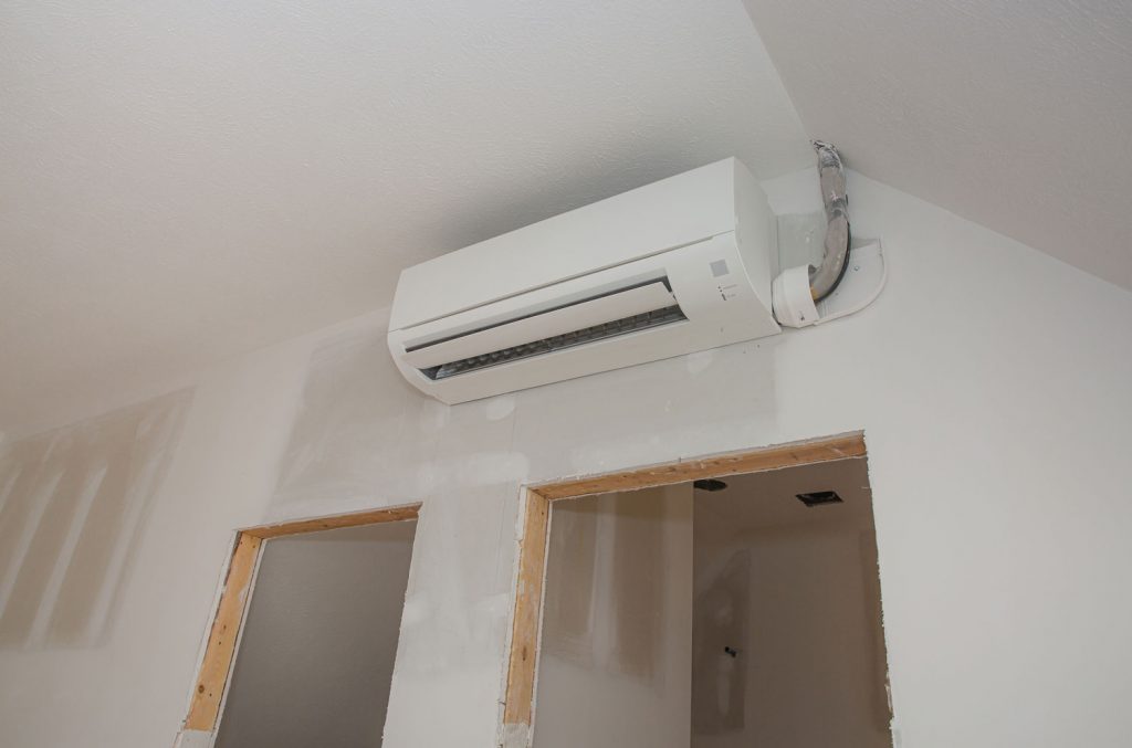 Mini-split ductless air conditioning unit installed in unfinished room