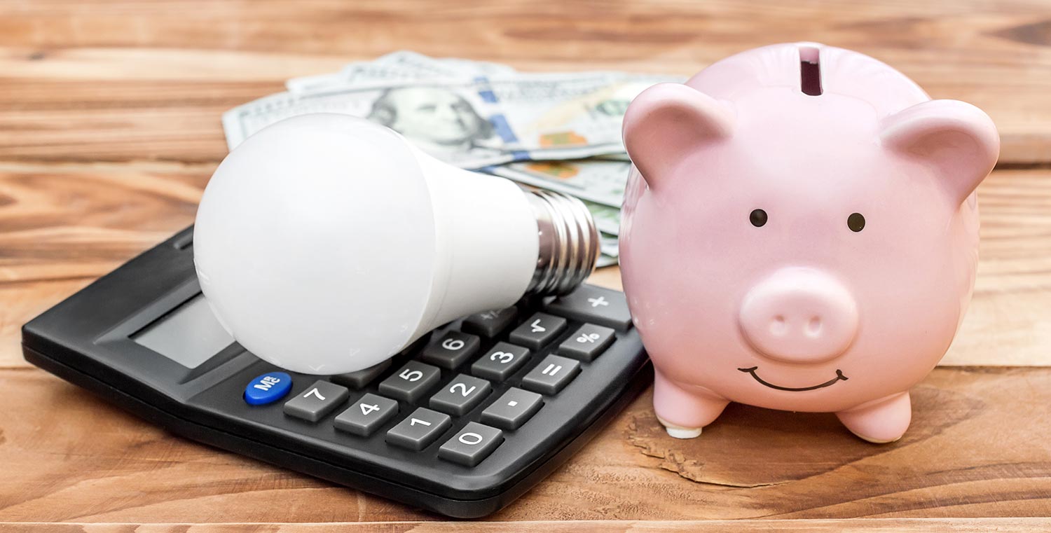 Piggy bank with light bulb, calculator and money