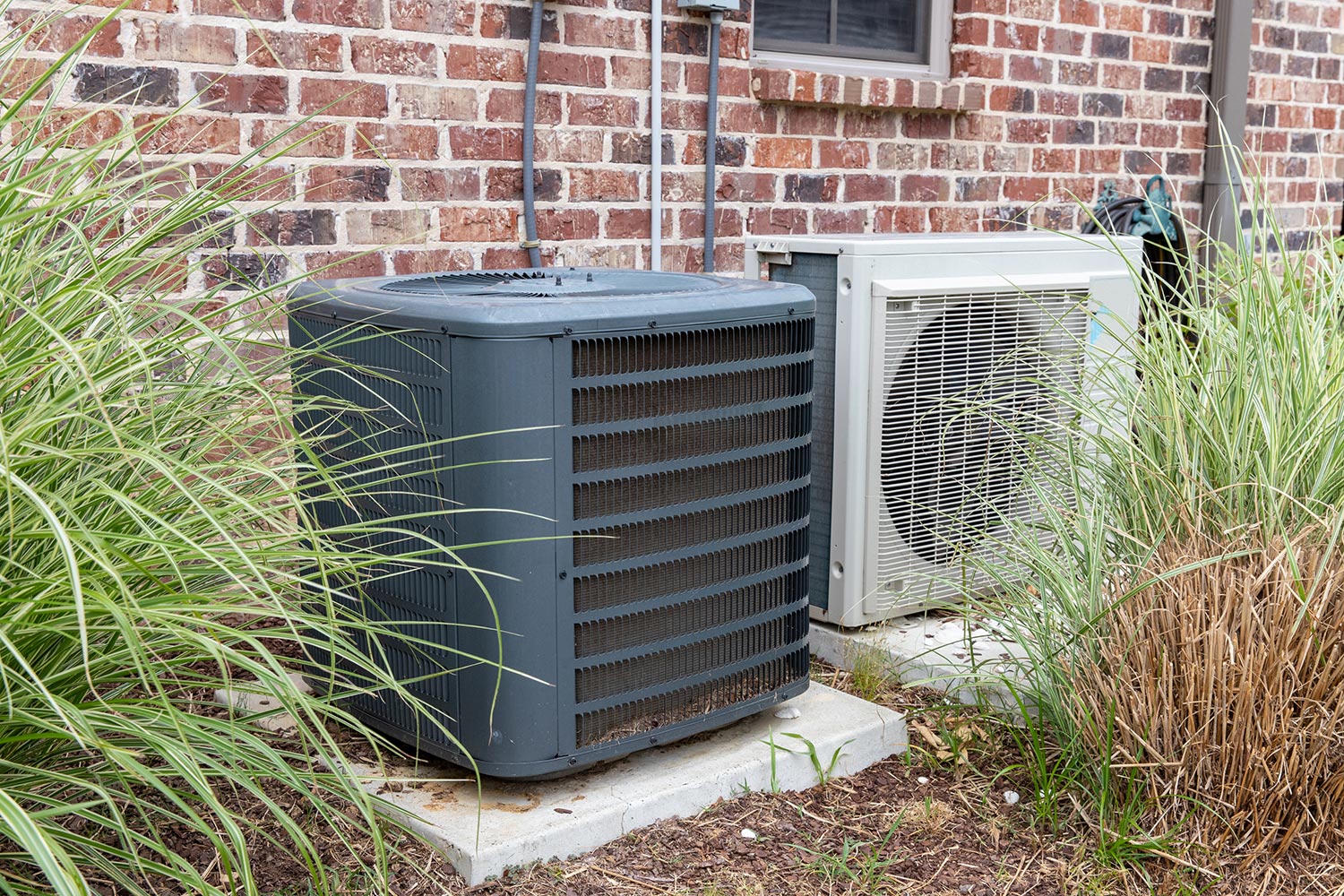 Regular home HVAC air conditioner system and mini-split next to each other