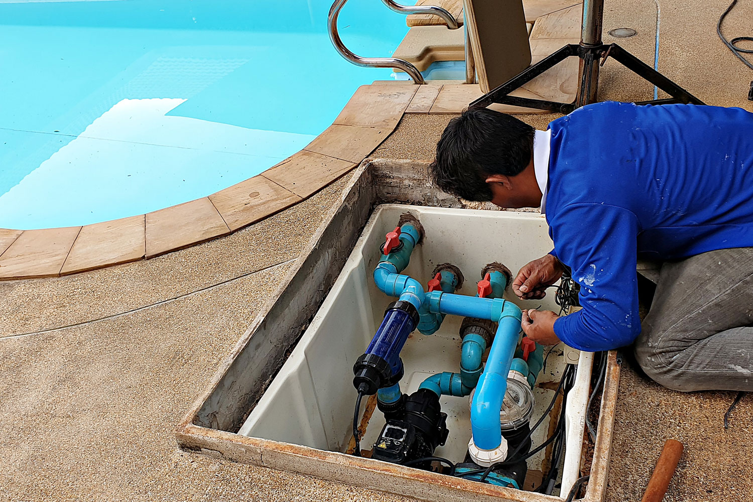 Technician checking the pool filter and heater 