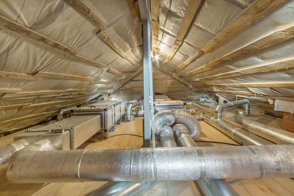 Ventilation pipes in silver insulation material on the attic