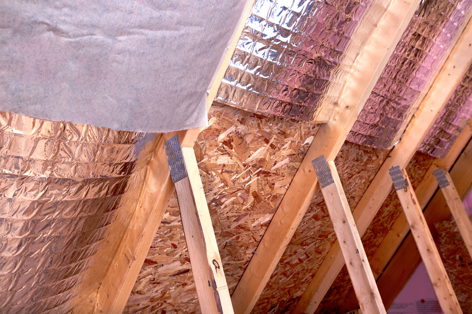 Wooden framing of a house with mineral insulation and radiant barrier sheathing