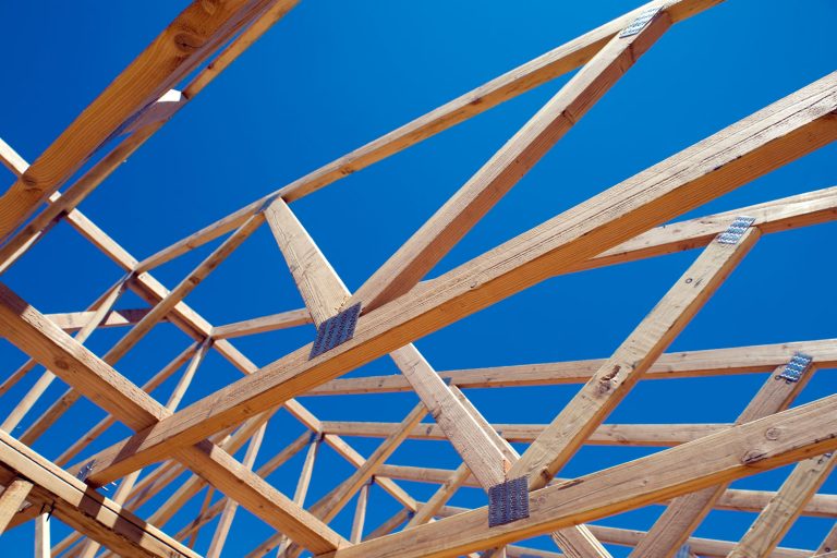 Wooden trusses at a house undergoing construction, How To Insulate Parallel Chord Trusses