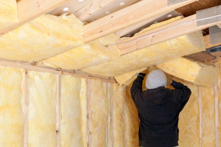 Worker installing fiberglass batt insulation between roof trusses, How To Insulate A Roof Without An Attic?