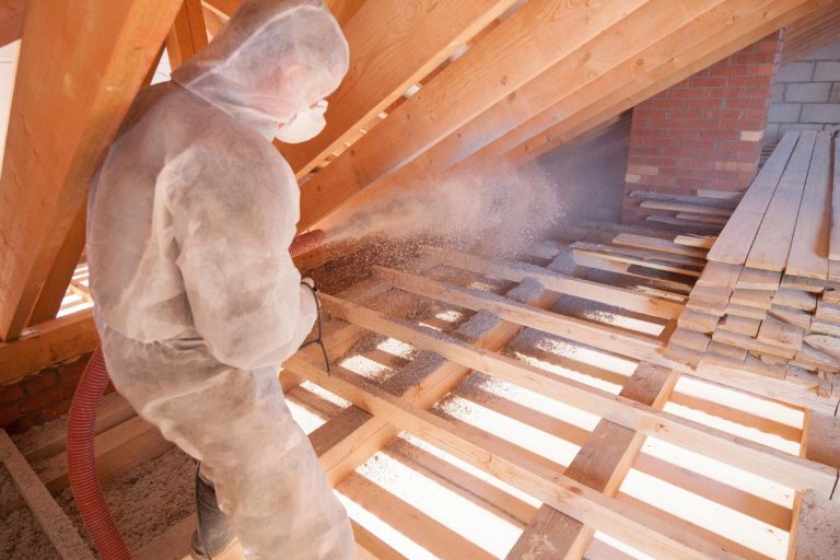 A worker with a hose is strewing ecowool insulation in the attic of a house, What Are The Types Of Loose-Fill Insulation?