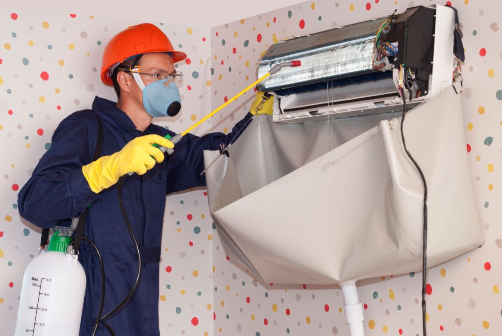 professional worker cleans the indoor unit of the air conditioner