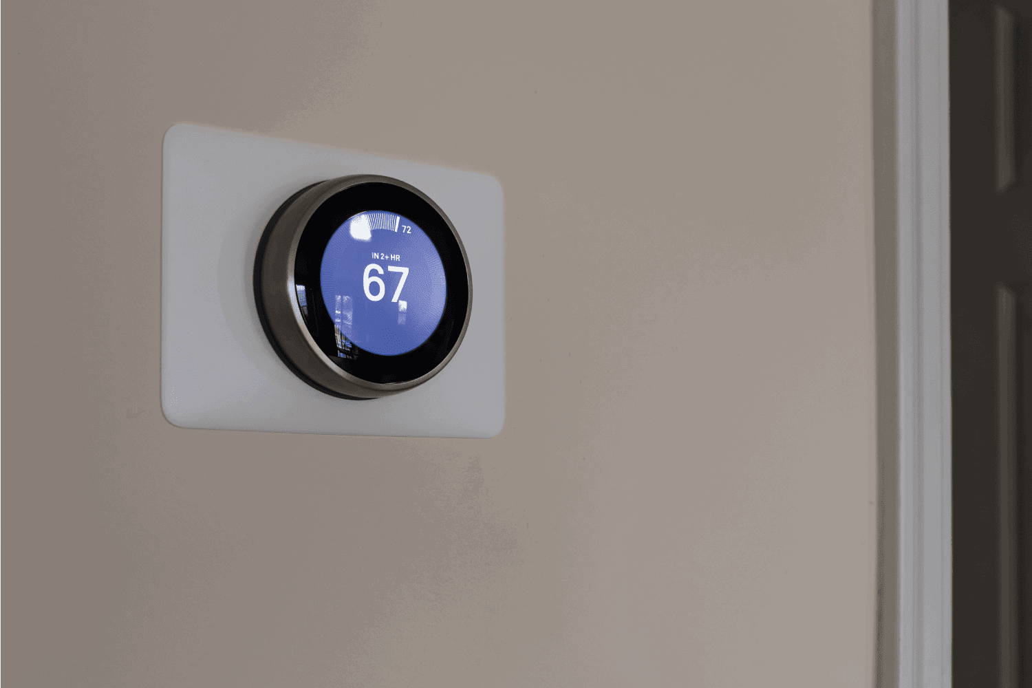 smart thermostat with violet screen on a white wall apartment