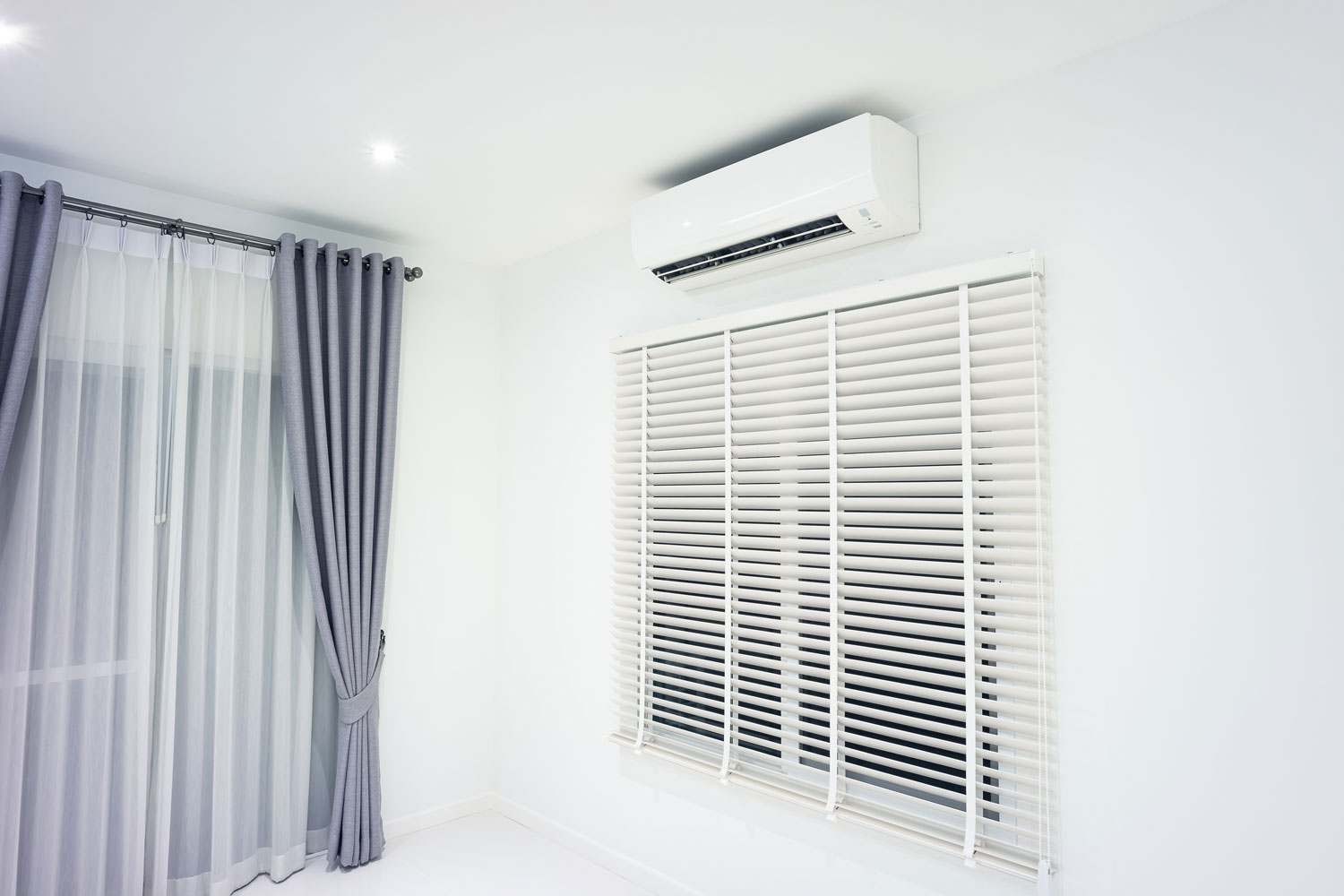 A mini split air conditioning unit mounted on top of the window
