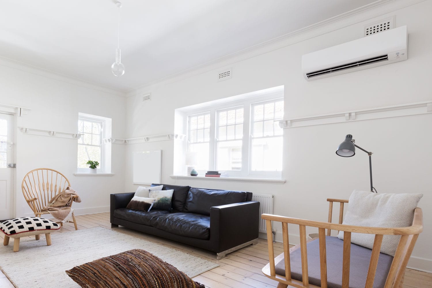 A small and spacious living room with white walls, wooden flooring and gorgeous wooden chairs, What Air Conditioners Work With Coolbot? [And How To Install One]