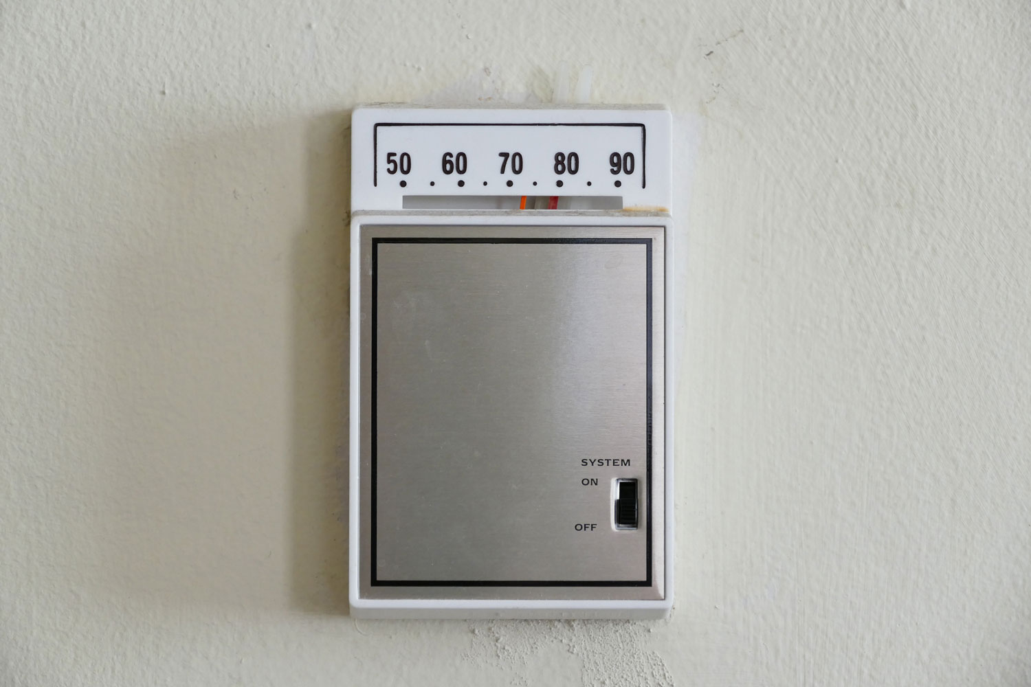 A thermostat control box placed on the wall