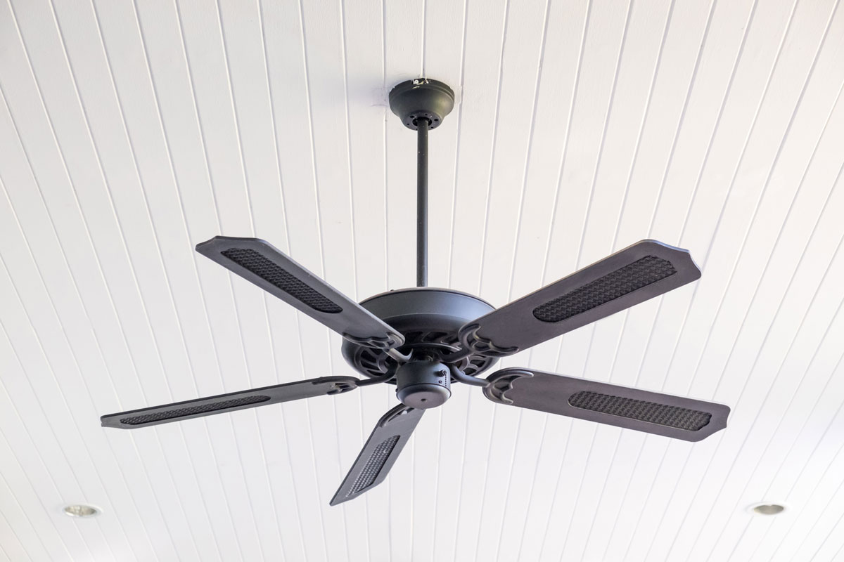 Electric ceiling fan attached on a white ceiling in living room, ceiling fan is perfect use for summer or hot days