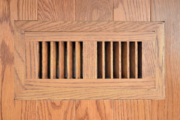 A heating vent in a residential home on hardwood floor, How Much Clearance Does A Floor Vent Need?