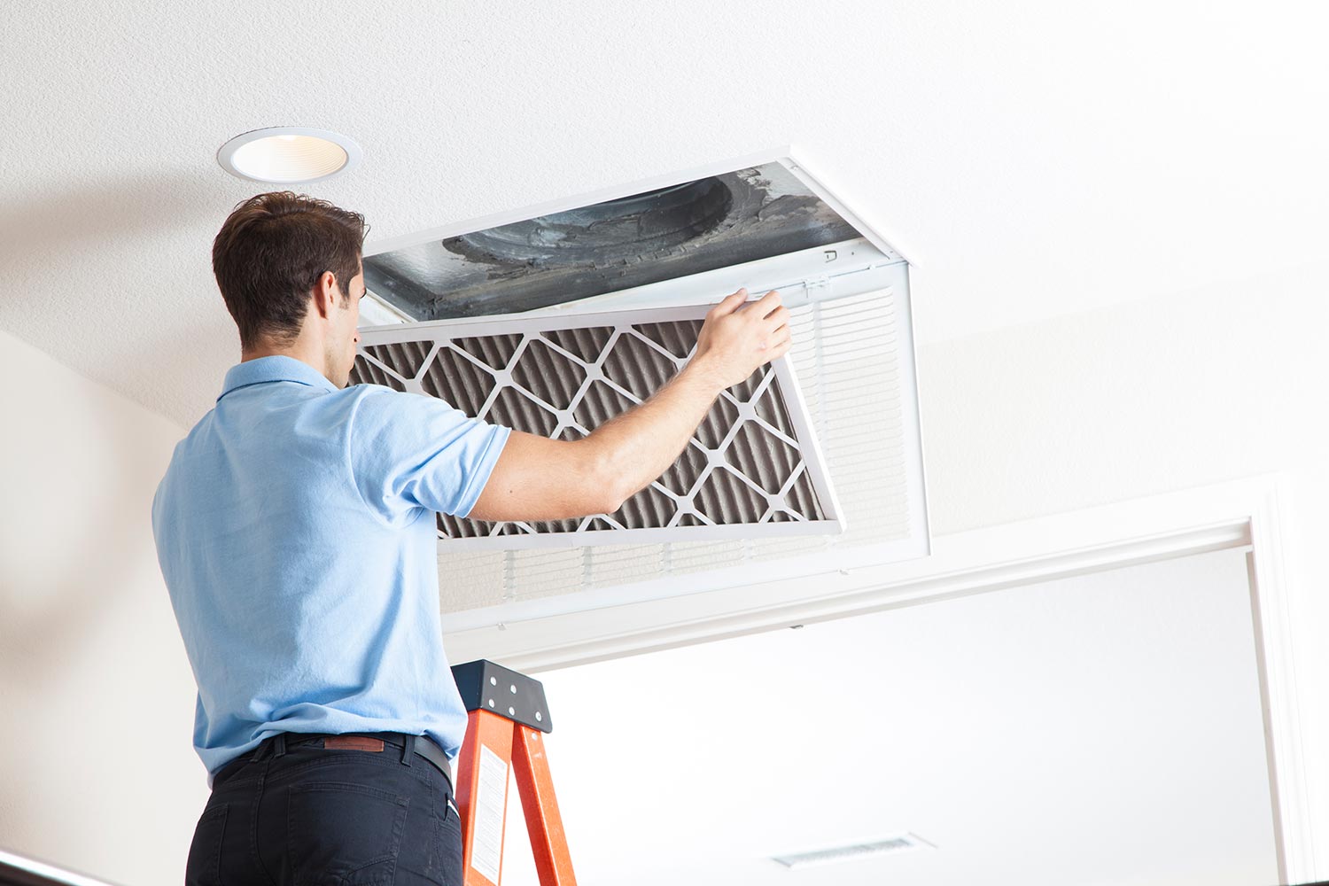 Man cleaning air ducts in home