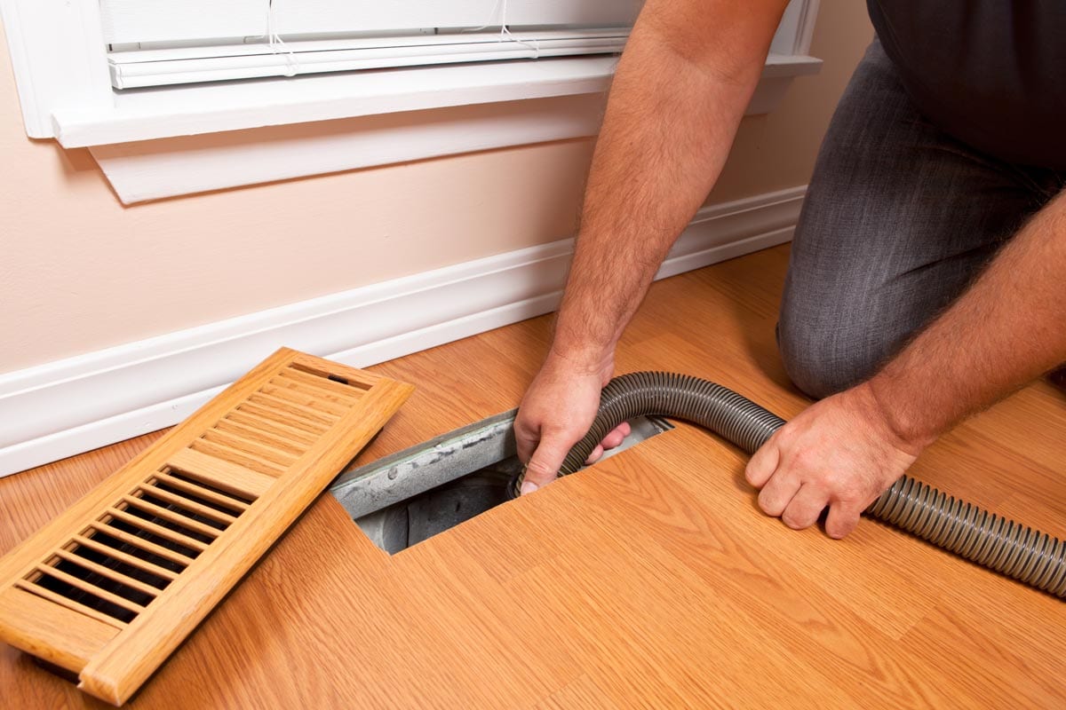 A man remove water inside the floor air vent, Water Flooded Into Floor Air Vent - What To Do?