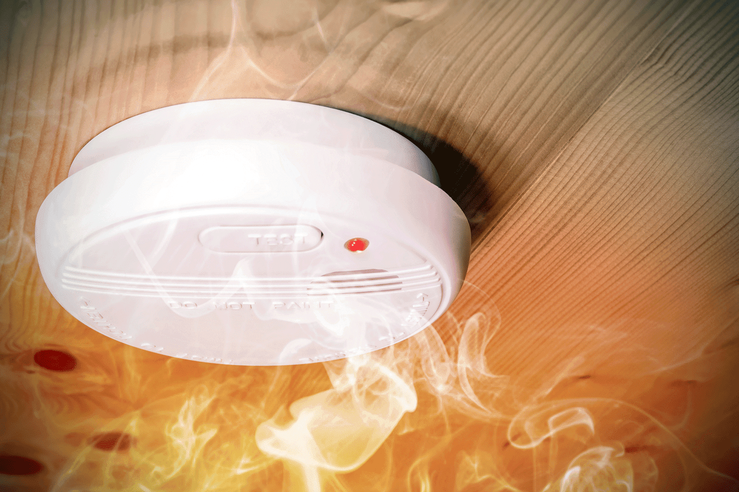 Smoke fire detected by home smoke detector alarm on ceiling