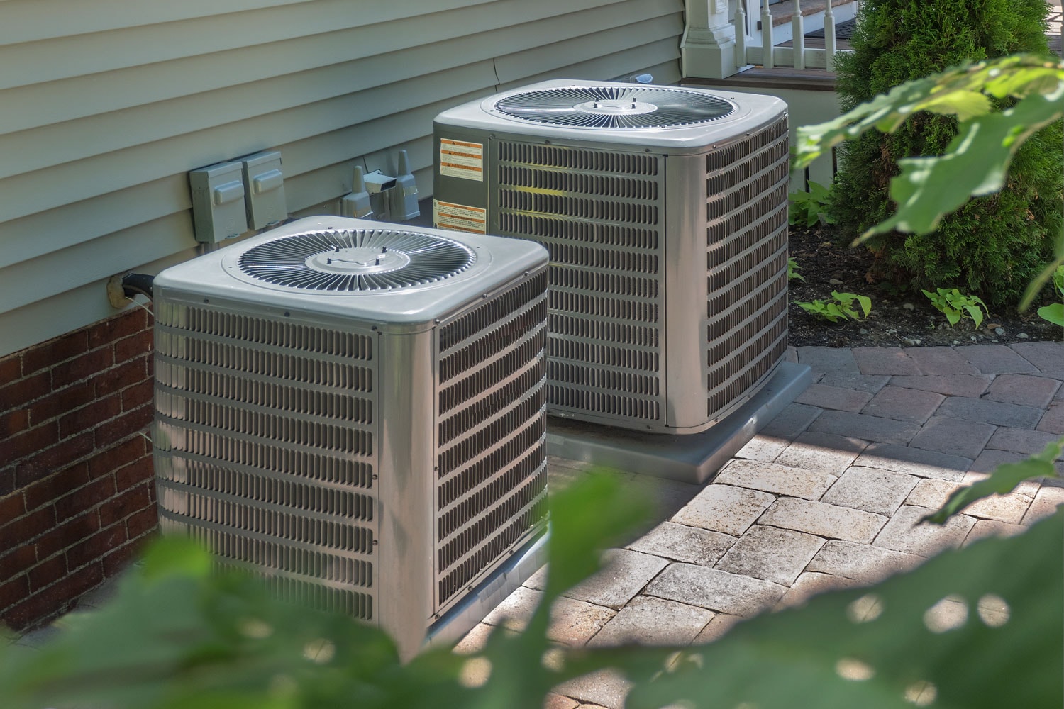 Two air conditioning units mounted on concrete stands