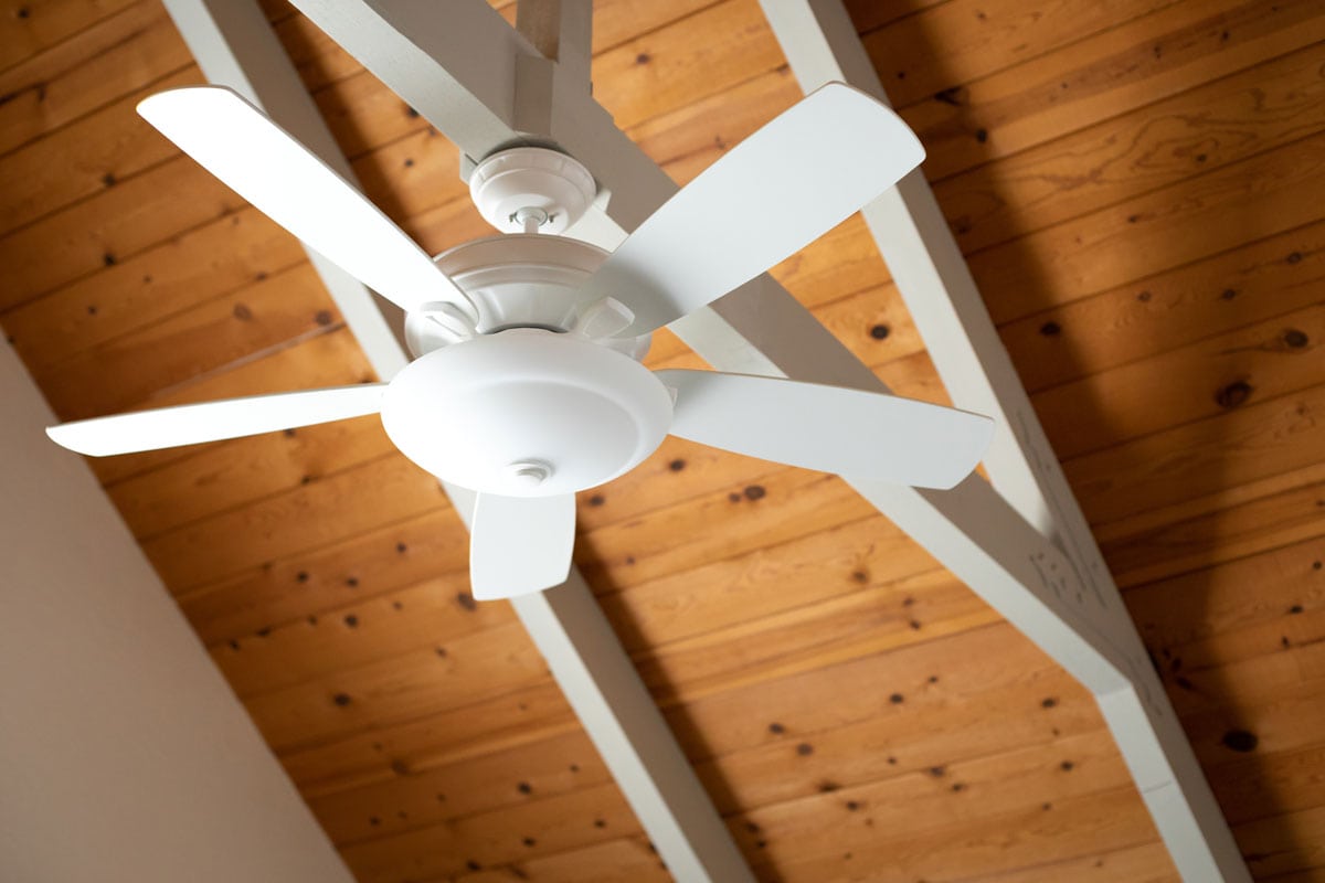 white ceiling fan on an exposed support beam
