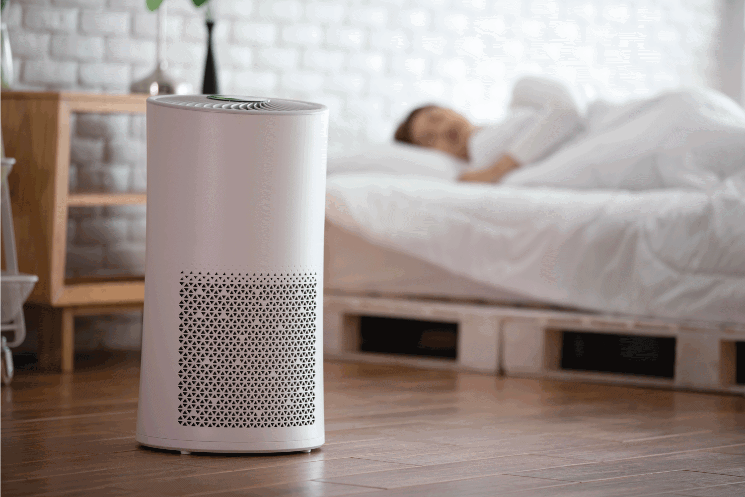woman sleep with Air purifier in cozy white bed room for filter and cleaning removing dust