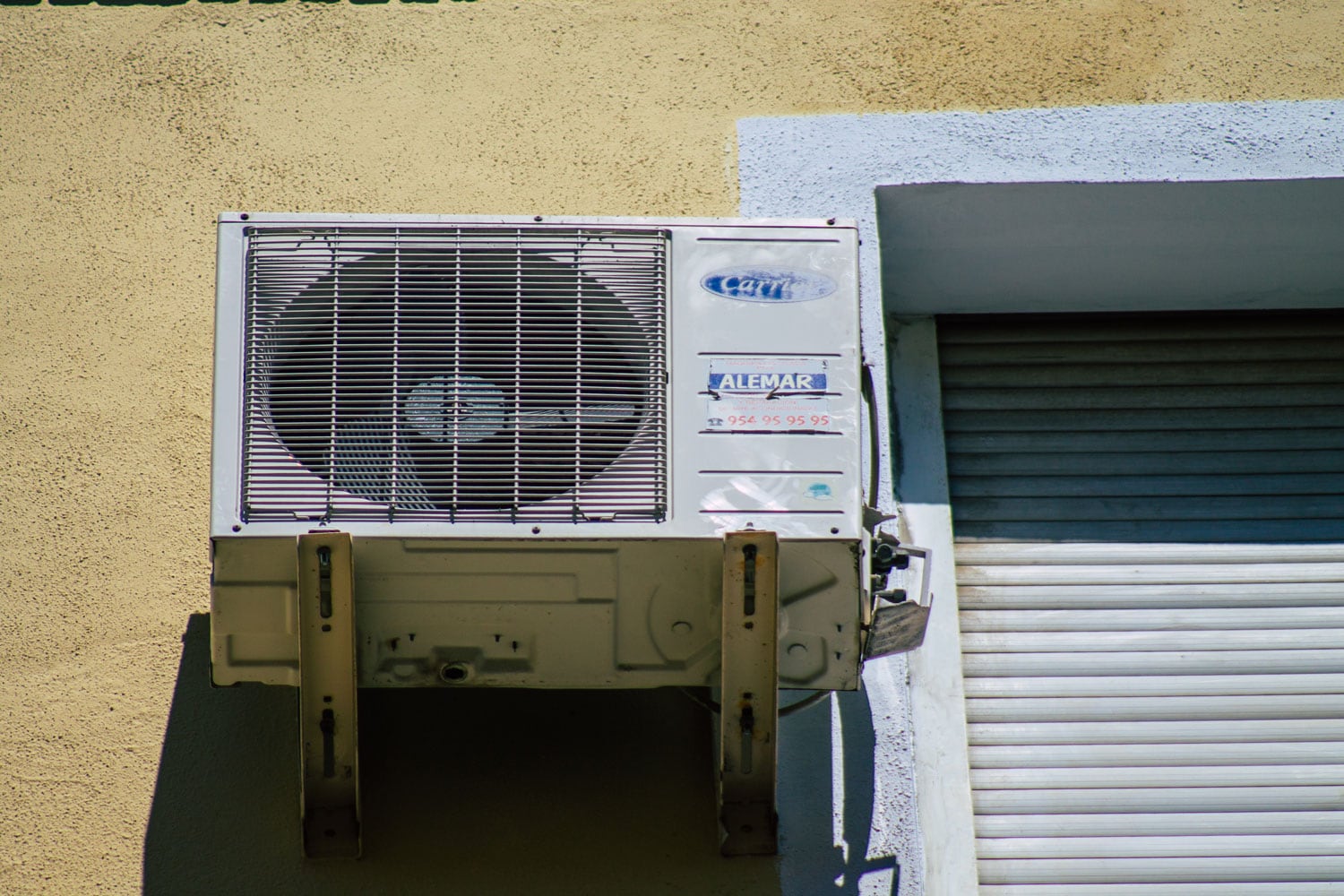 A Carrier air conditioning unit mounted on reinforced support brackets for wall mounting