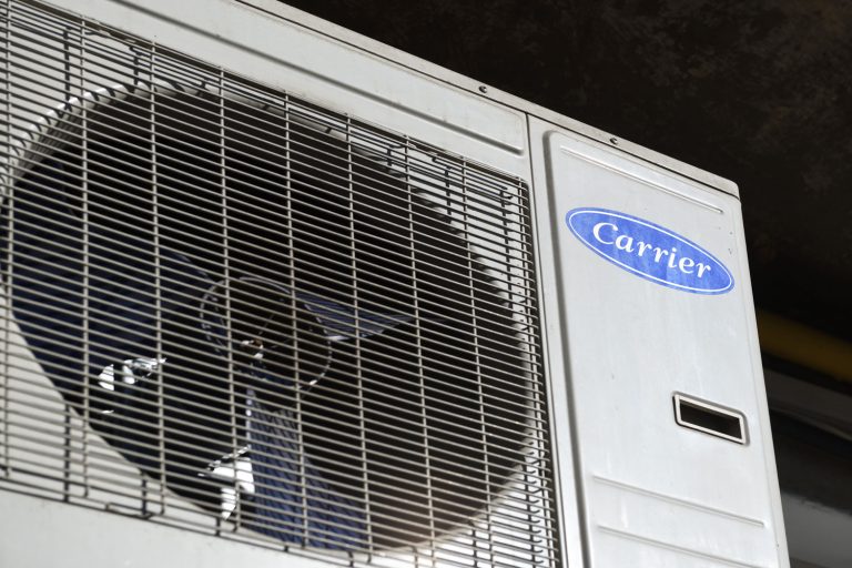 A Carrier air conditioning unit mounted on the side of the wall, How Long Does A Carrier Air Conditioner Last?
