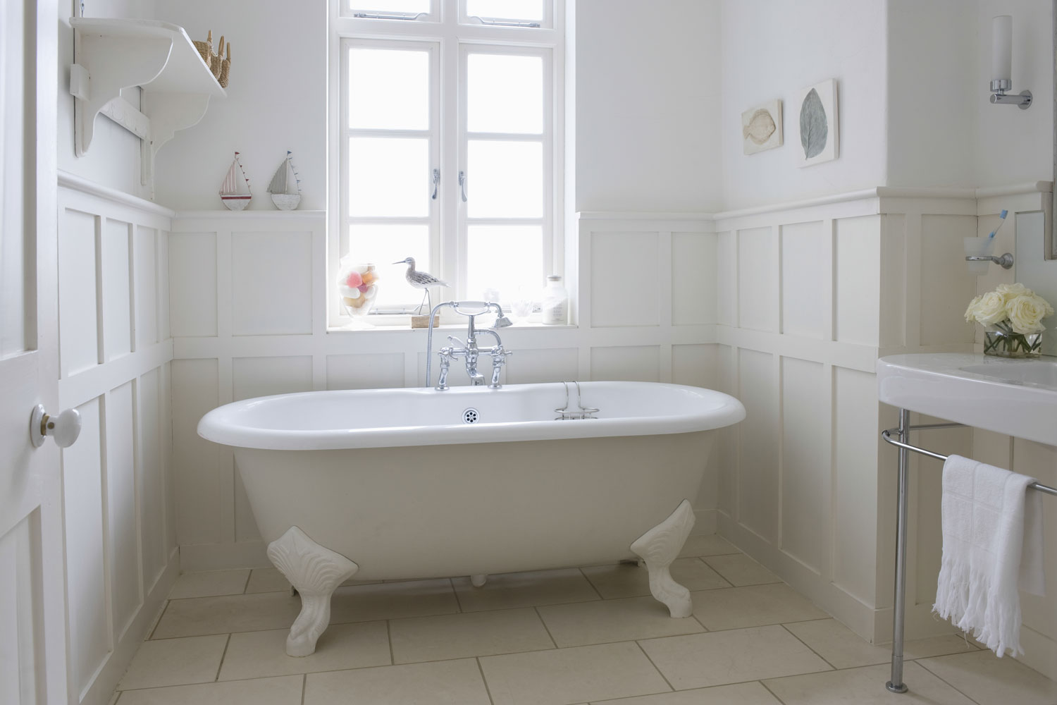 A freestanding white bathtub inside a classic inspired bathroom