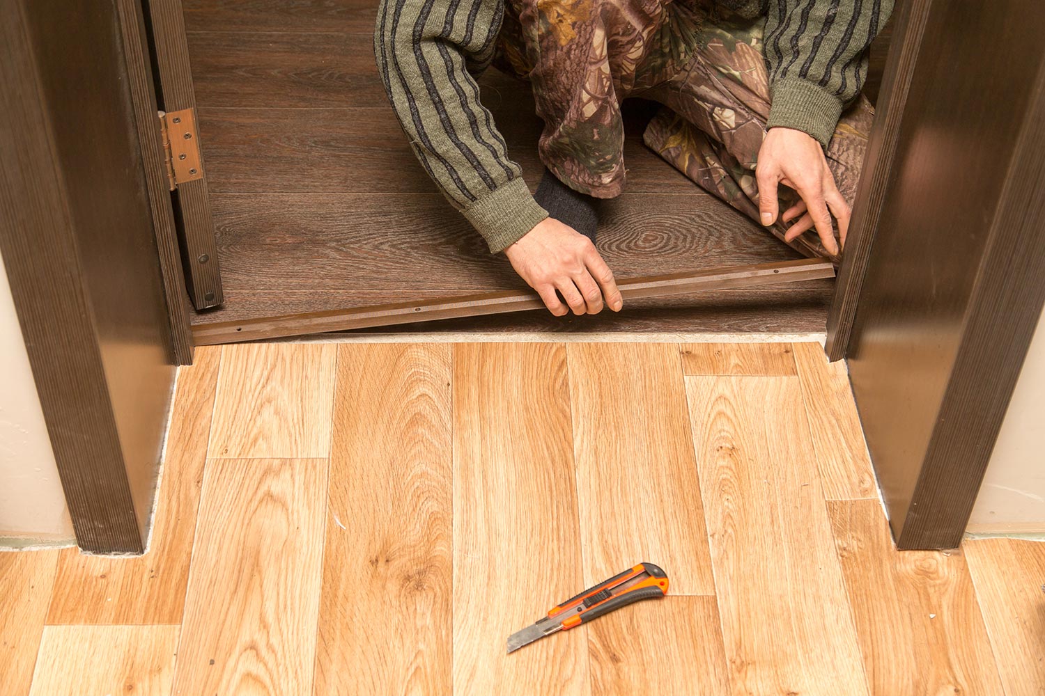 A man is making a threshold on the floor