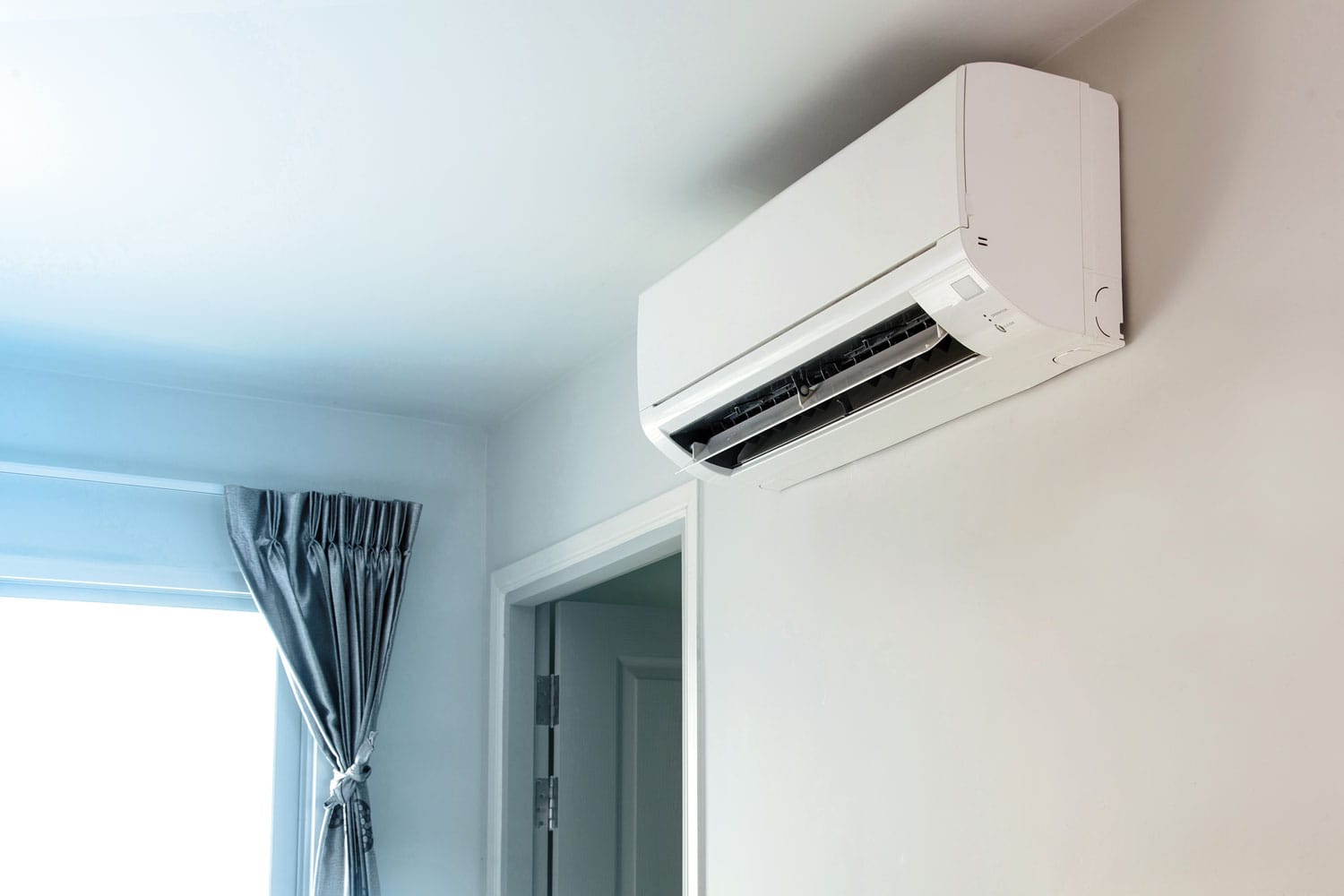 A mini split AC unit mounted on the living room wall