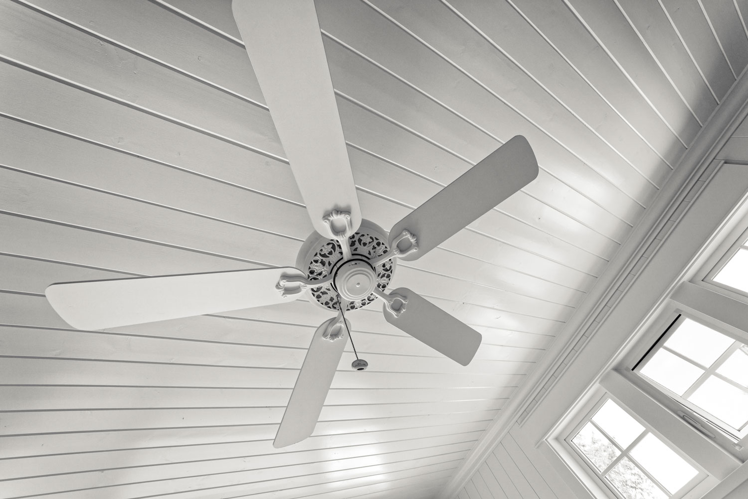 A white classic ceiling fan inside a white living room