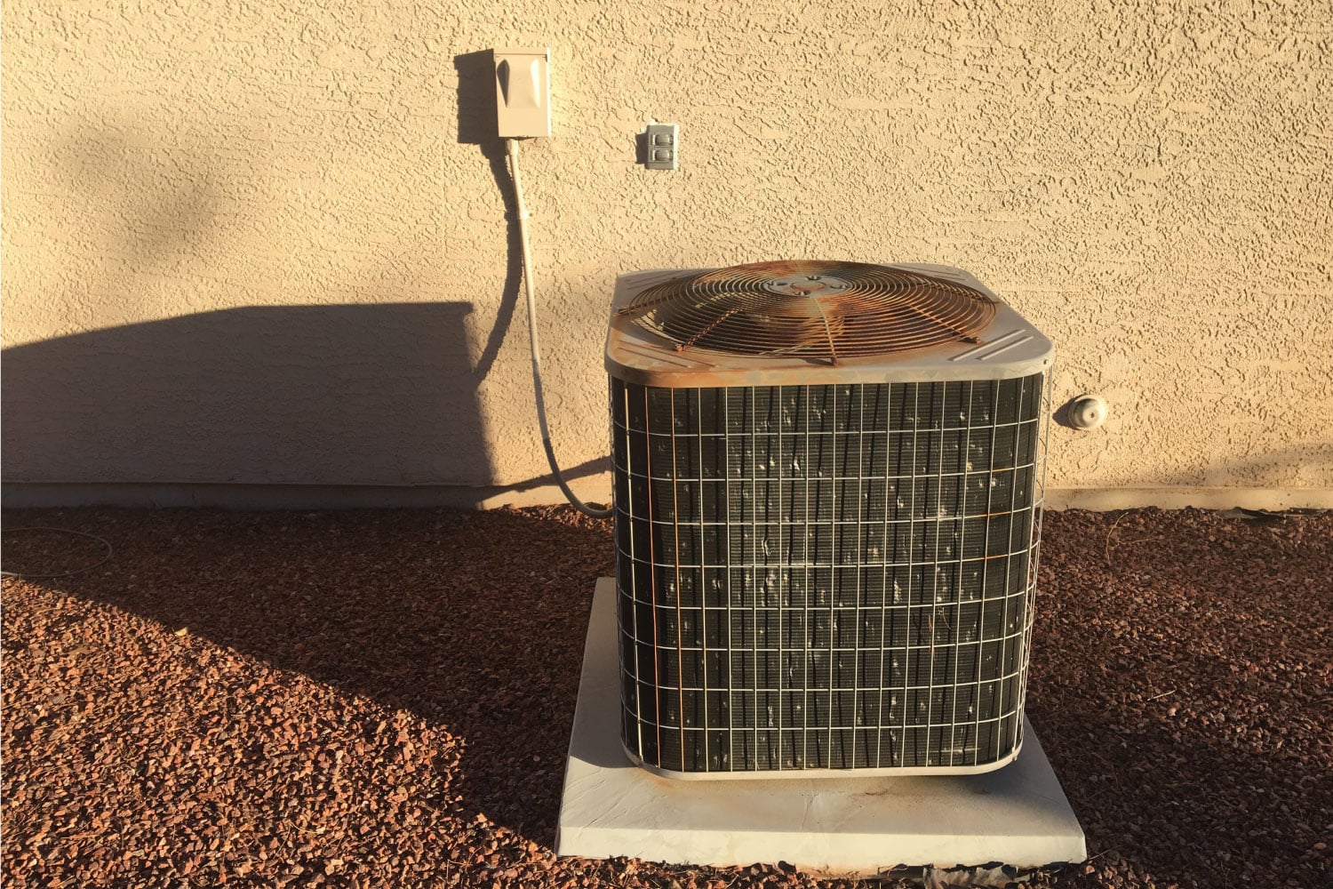 Air conditioning unit machine outside stucco red rock southwest hot heat summer