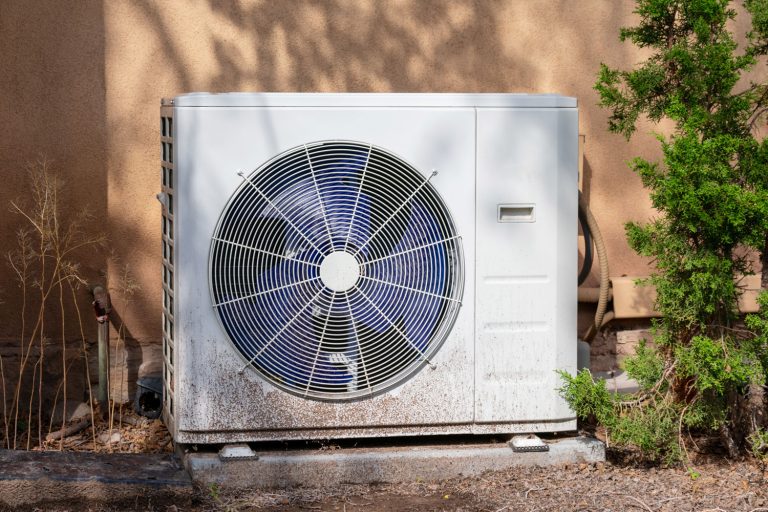 An Air compressor unit outside a house, How To Reset A GE Air Conditioner