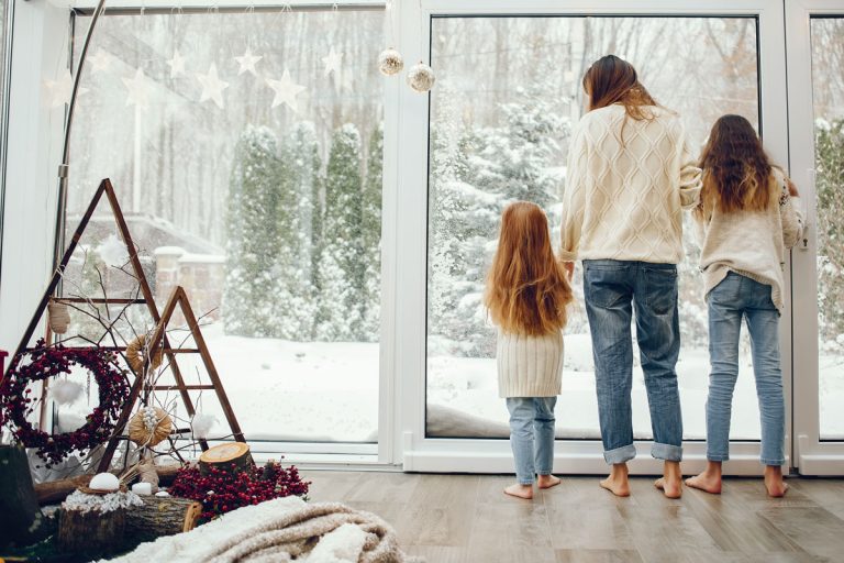 Beautiful mother with children. Family at home. People standing near winter windows, How To Get Fresh Air From Outside Without Letting Cold Air In