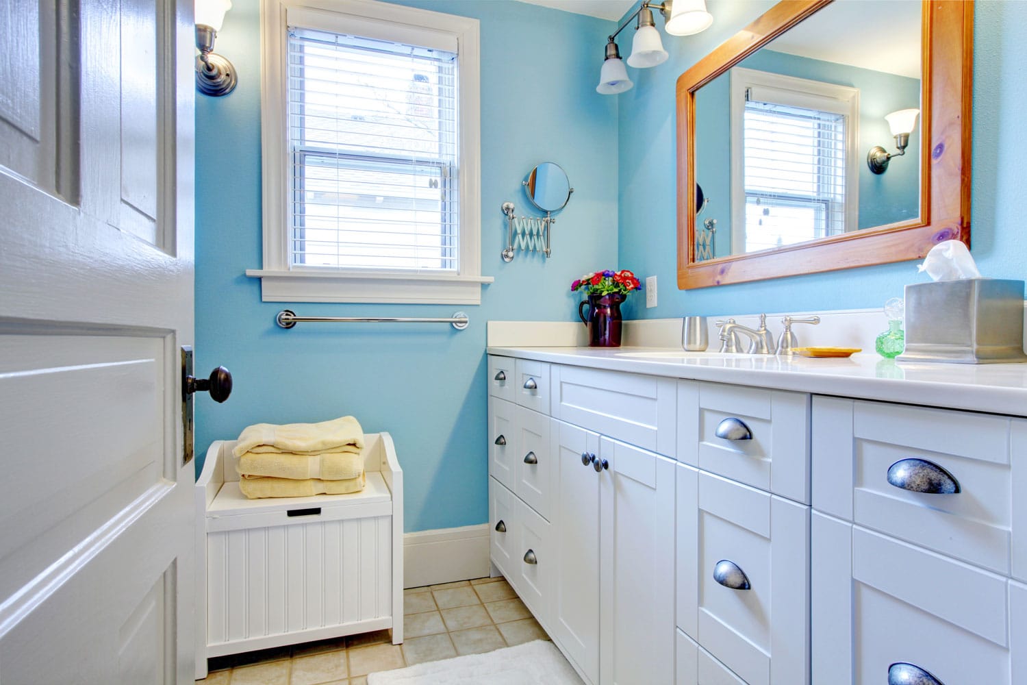 Bright nautical inspired bathroom with white cabinets on the vanity