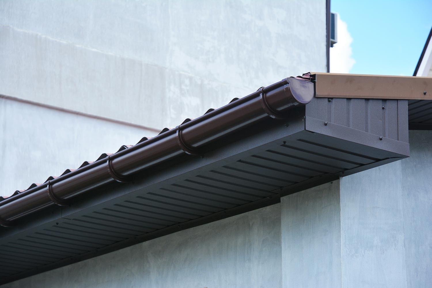 Close up on house plastic roof gutter with soffit and fascia board