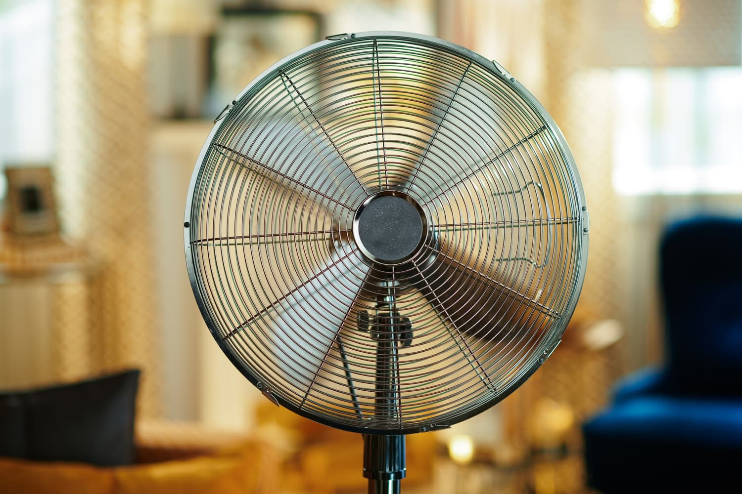 Closeup on electric floor standing fan at modern home in sunny hot summer day.
