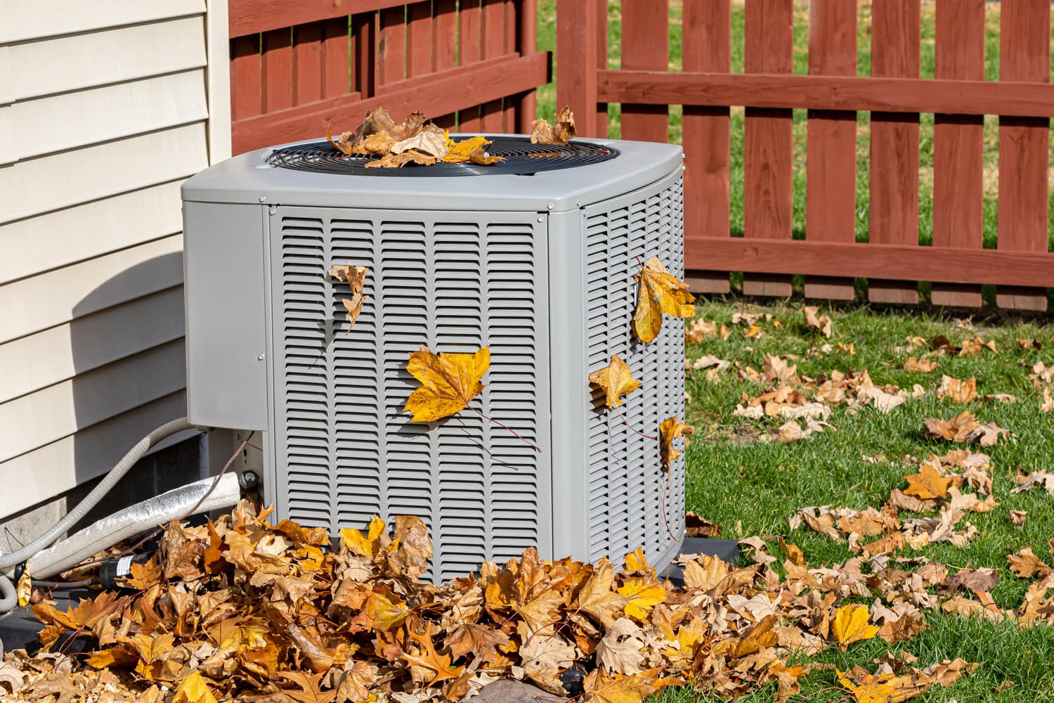 Dirty air conditioning unit covered in leaves during autumn. Home air conditioning, HVAC, repair, service, fall cleaning and maintenance.