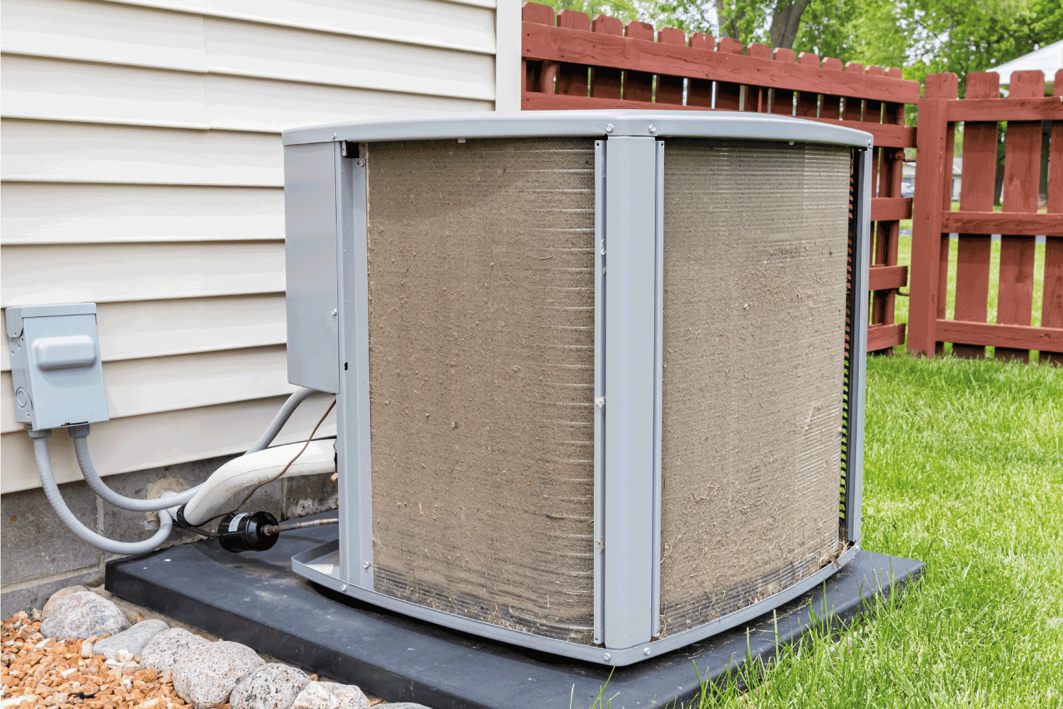 Dirty air conditioning condenser unit. Condenser coil full of dirt and grass debris