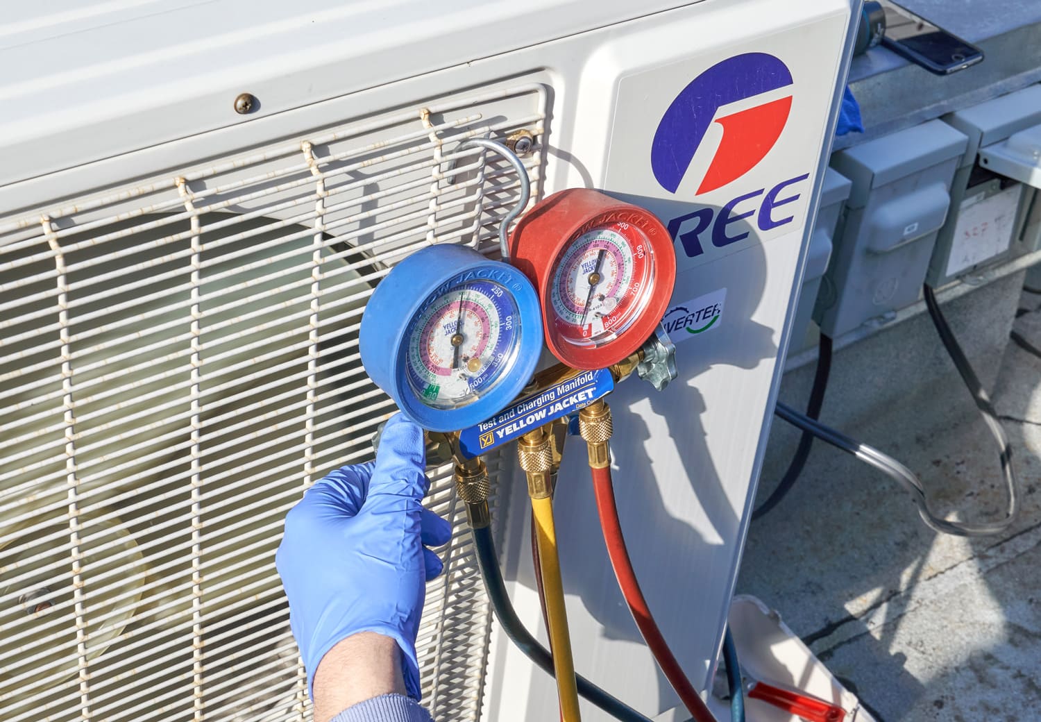 Engineer checking AC refrigerant level and refilling freon.