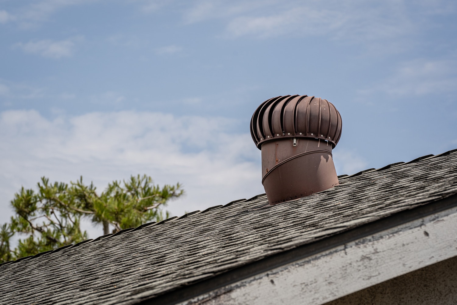 Old Residential House Roof with Aluminum Roof Turbine Vent on Blue Sky Outdoor Ventilation Wind Efficiency Energy