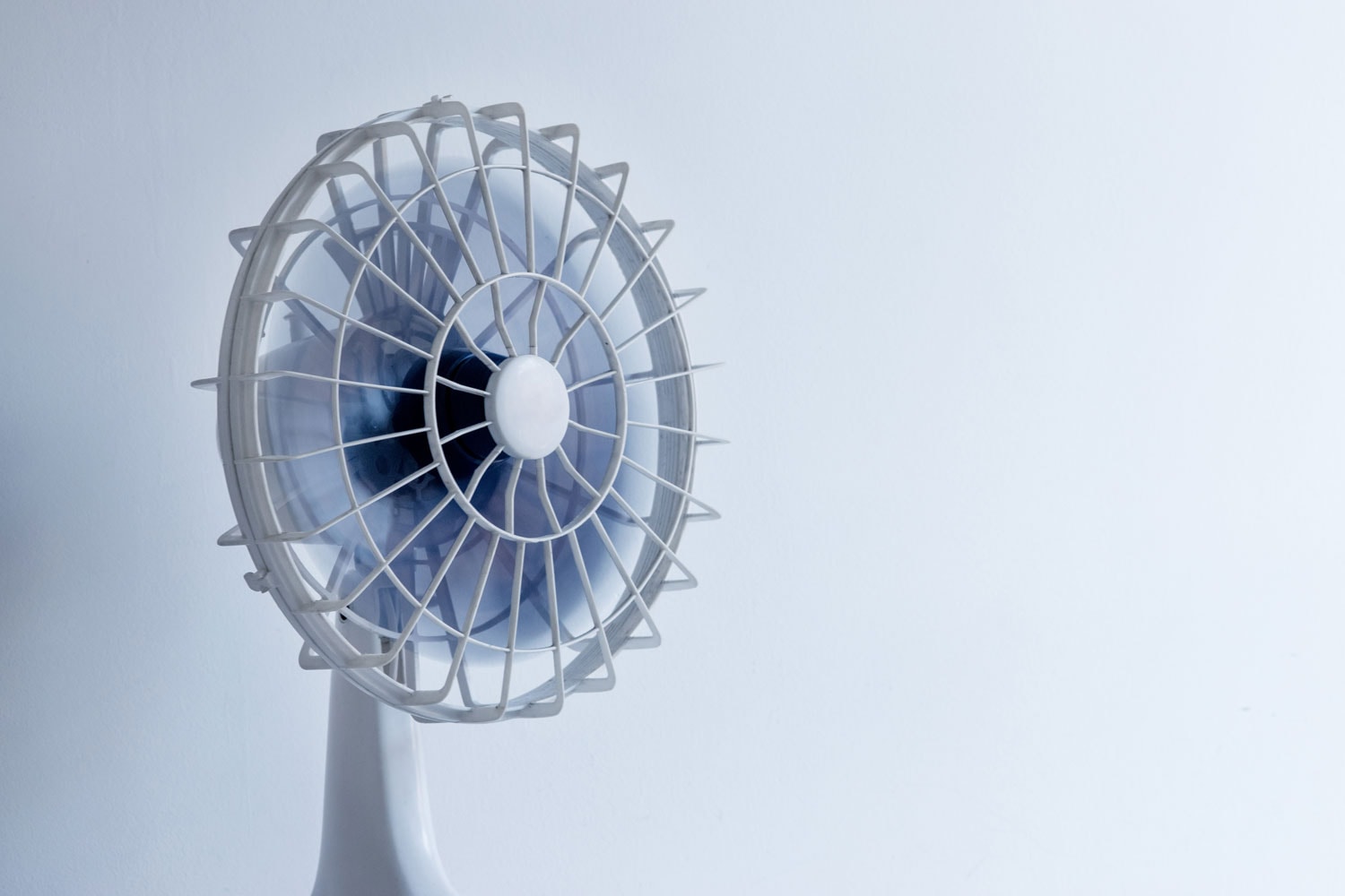 Small white stand fan inside a room