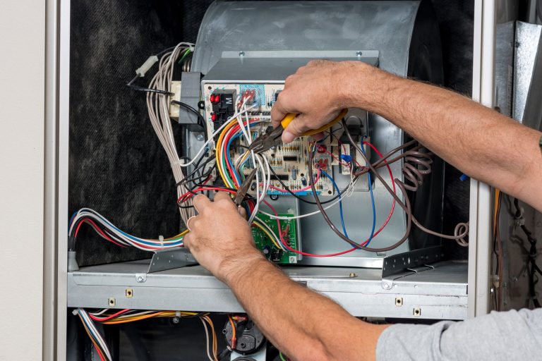 Technician cutting wires in the Goodman furnace due to error codes, Goodman Furnace Error Codes And What They Mean