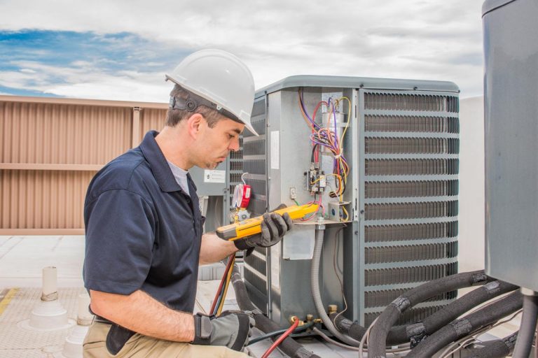 A trained hvac technician performing preventative maintenance on a air conditioning condenser unit, How Long is Rheem AC Warranty and Does It Cover Labor?