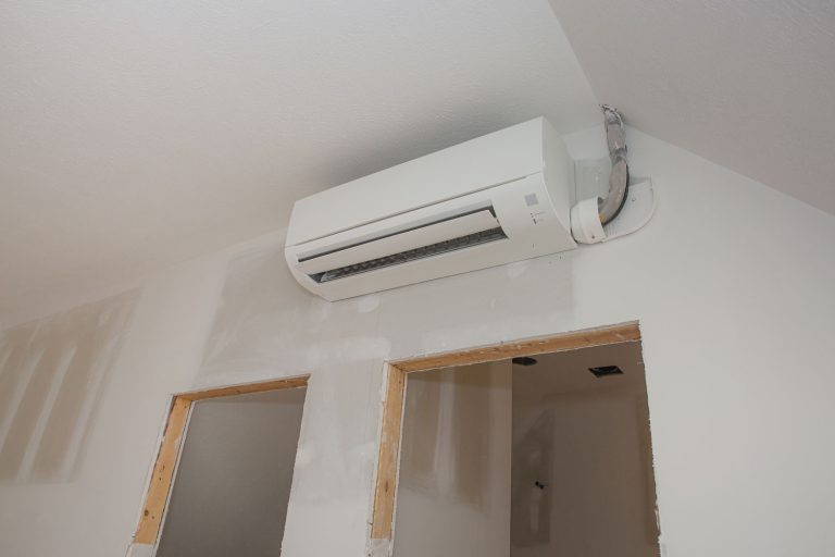 Unfinished door jamb and an AC unit mounted on the living room wall, Do Ductless Air Conditioners Remove Humidity?
