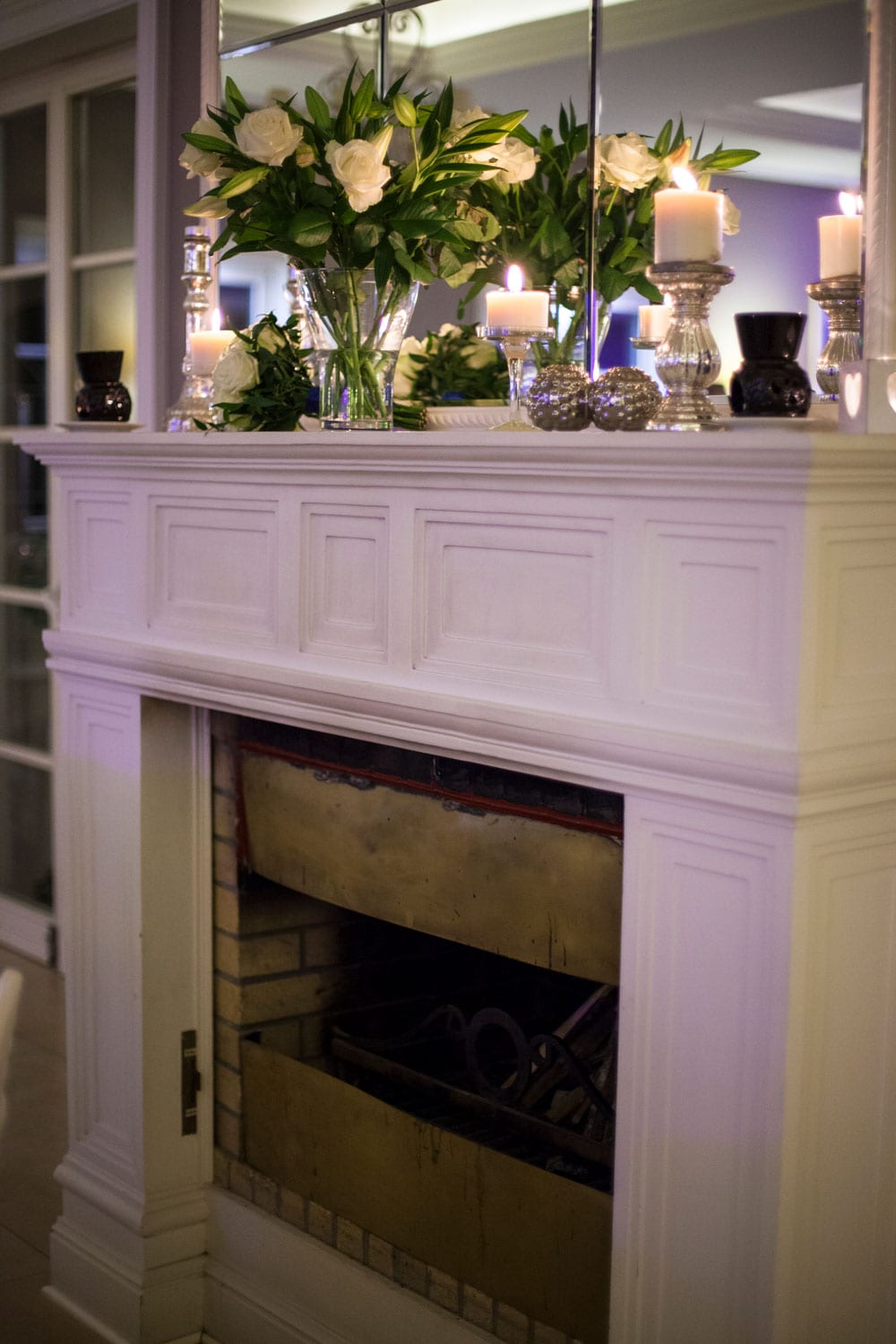 White fireplace mantel with flowers on top