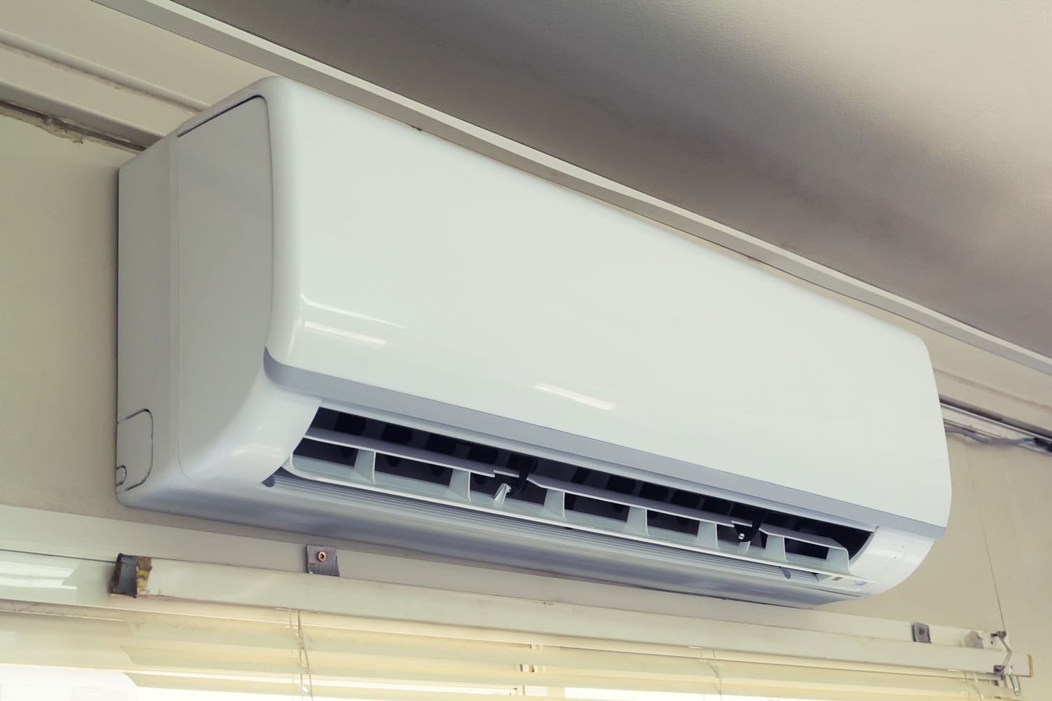 A big AC unit mounted on the side of the living room wall