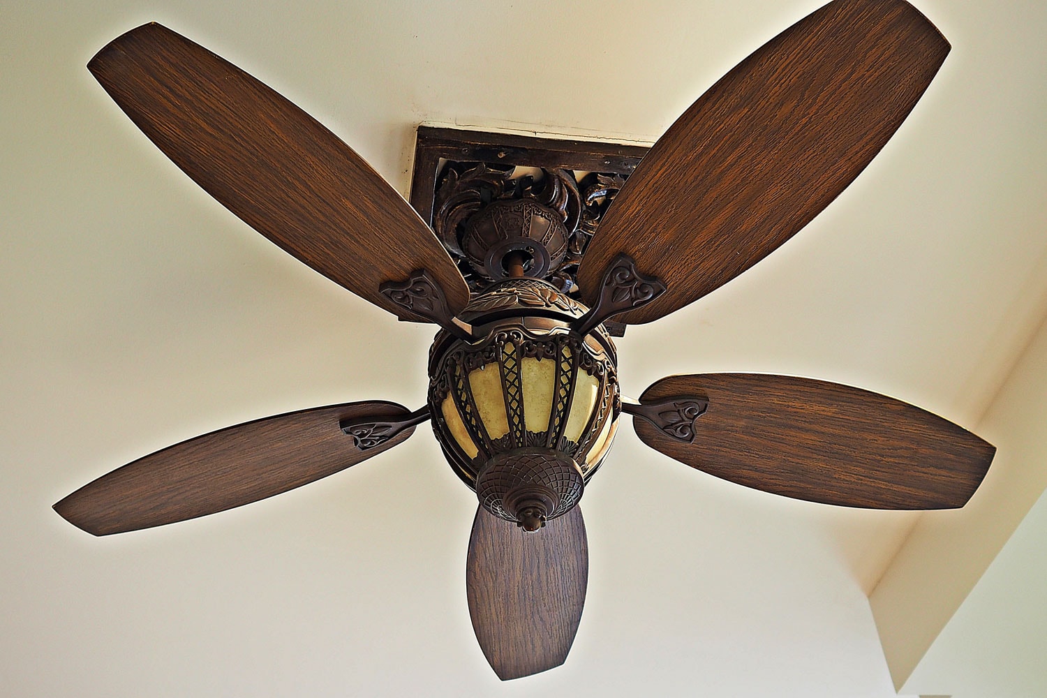 A brown wooden ceiling fan inside a big living area