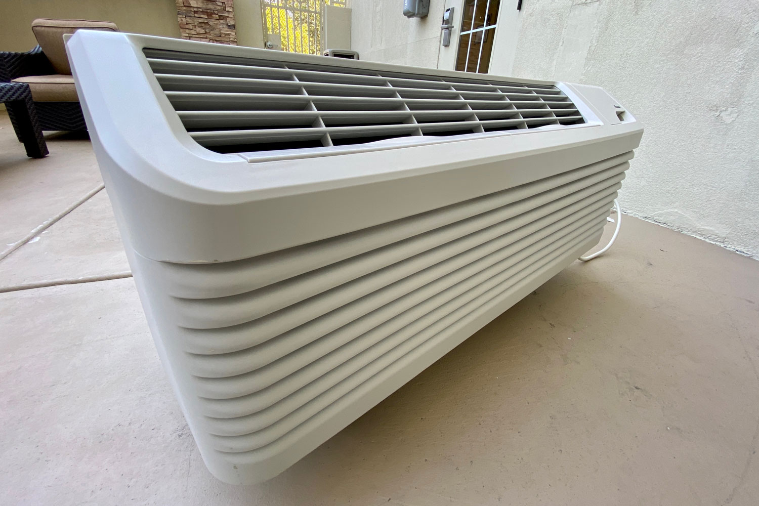 A white portable AC unit inside the living room