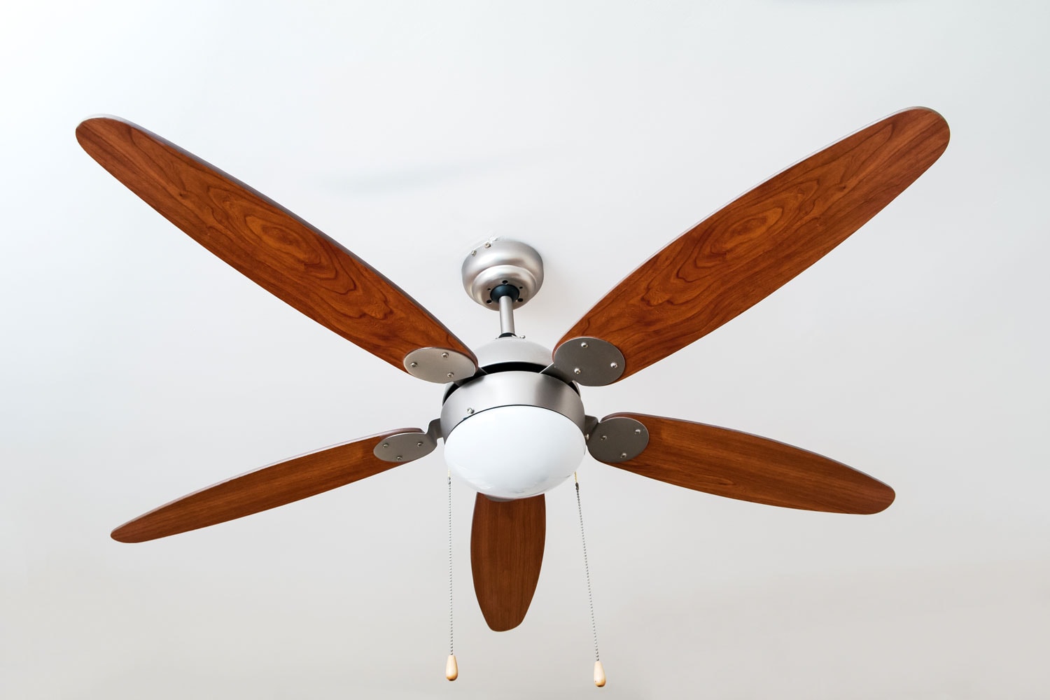A wooden ceiling fan inside a bright living room