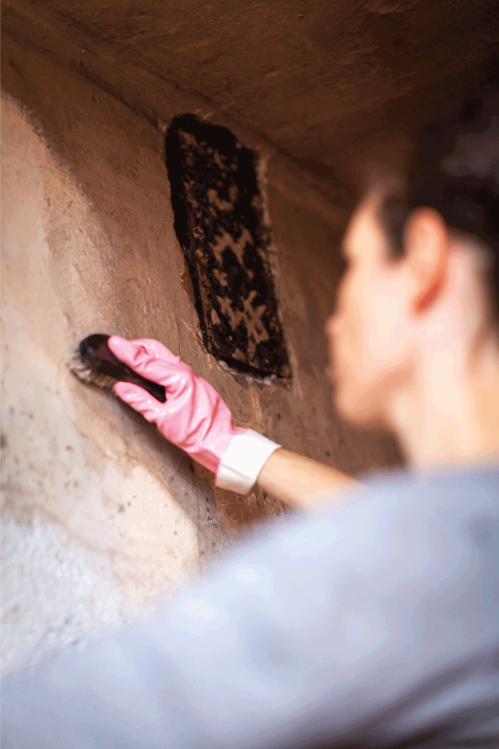 Adult Woman Cleaning and Renovating Wall in an Old Kitchen.