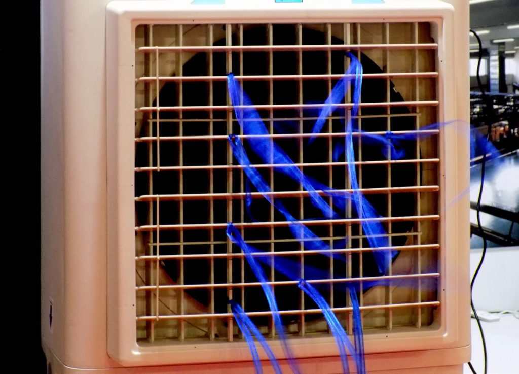 Air conditioner with blue ribbons flying over the air stream produced by the fan